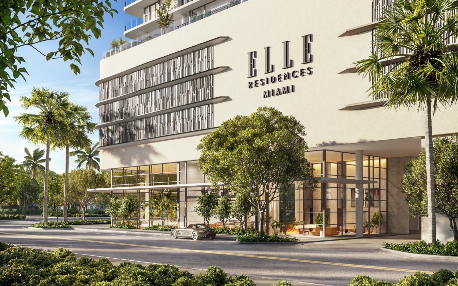 Street-level entrance to ELLE Residences Miami lined with palm trees in Edgewater