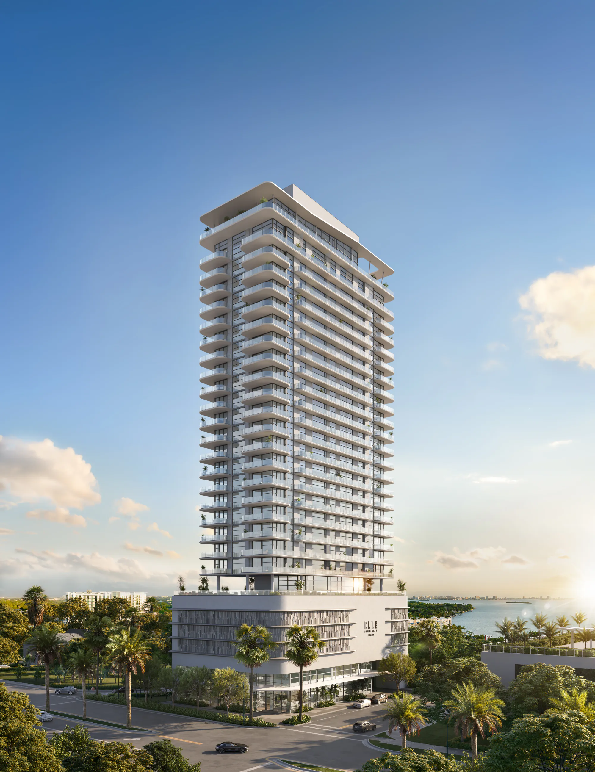 ELLE Residences Miami, full tower view showing curved white balconies and palm-lined entrance